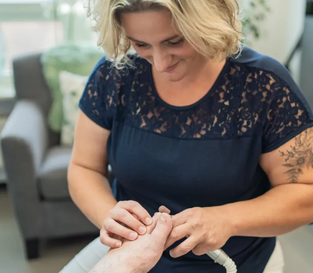 Podologin bei der Nagelpflege einer Patientin im Behandlungsraum